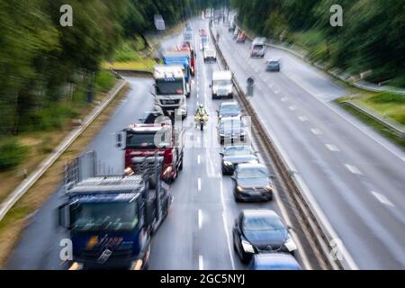 Bremen, Germany. 06th Aug, 2021. Roger Jahn, ADAC dust consultant, rides his motorcycle along the B75 between cars during a traffic jam. Holiday time can require a lot of waiting and patience as well as rest and relaxation. In view of the summer holidays, there are currently roadside cleanliness advisors on the roads on their motorcycles, advising and giving tips on how to get around the traffic jam as quickly as possible. Credit: Sina Schuldt/dpa/Alamy Live News Stock Photo