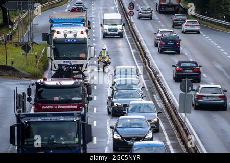 Bremen, Germany. 06th Aug, 2021. Roger Jahn, ADAC dust consultant, rides his motorcycle along the B75 between cars during a traffic jam. Holiday time can require a lot of waiting and patience as well as rest and relaxation. In view of the summer holidays, there are currently roadside cleanliness advisors on the roads on their motorcycles, advising and giving tips on how to get around the traffic jam as quickly as possible. Credit: Sina Schuldt/dpa/Alamy Live News Stock Photo