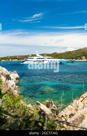 Stunning view of a bay of water with luxury yachts sailing on a turquoise water during a sunny day. La Maddalena archipelago, Sardinia, Italy. Stock Photo