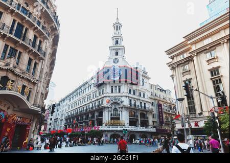 The historic building of Shanghai with a clock and bell tower at a corner of Nanjing Road and pedestrian street in downtown Shanghai city, China Stock Photo