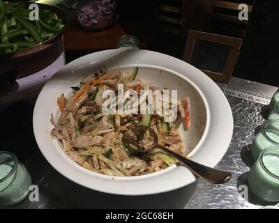 Tasty pork salad served in a white serving bowl. Stock Photo