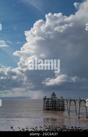 Clevedon Pier with blue sky and large stormy cumulus clouds over the Welsh coast Stock Photo