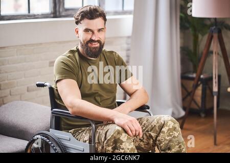Disabled ex-serviceman wearing military uniform and sitting in a wheelchair Stock Photo