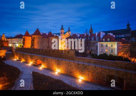 Poland, Masovia, Warsaw, Old City walls and barbican illuminated at night Stock Photo