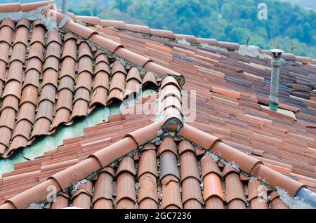 House: pitched roofs with brick tiles, visible the upper pitch line and the ridge tiles. Stock Photo