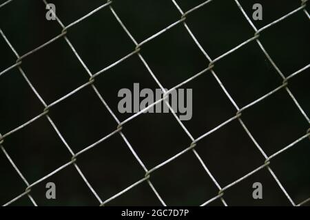 wire mesh fence with dark background Stock Photo