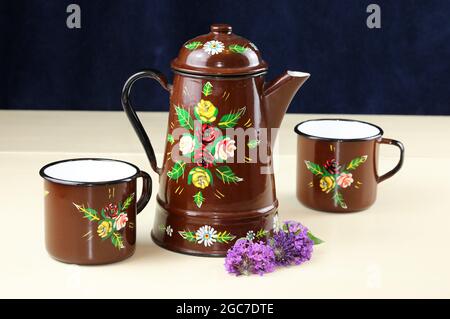 An Image Of A Brown Enamel Coffee Pot Painted With Roses Stock Photo