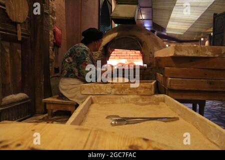 Arab woman kneading and then baking Stock Photo