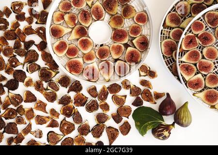 Fresh figs in a dehydrator lie next to dried figs on the table Stock Photo