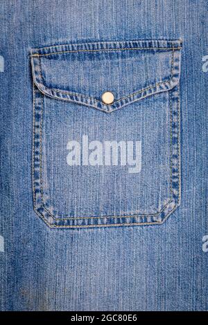 Blue jeans texture. Part of a jeans jacket with pocket close-up. Stock Photo