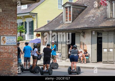 NEW ORLEANS, LA, USA - JULY 31, 2021: Tour group on Seqways at the corner of Bourbon Street and St. Philip Street Stock Photo