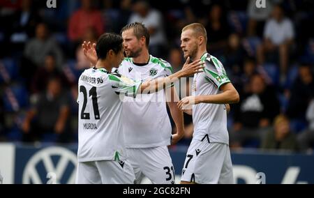 07 August 2021, Schleswig-Holstein, Norderstedt: Football: DFB Cup, Eintracht Norderstedt - Hannover 96, 1st round at Edmund-Plambeck-Stadion. Hannover's Marvin Ducksch (r) celebrates with teammates Sei Muroya (l) and Julian Börner after scoring the 0:2 goal. IMPORTANT NOTE: In accordance with the regulations of the DFL Deutsche Fußball Liga and the DFB Deutscher Fußball-Bund, it is prohibited to use or have used photographs taken in the stadium and/or of the match in the form of sequence pictures and/or video-like photo series. Photo: Daniel Reinhardt/dpa - IMPORTANT NOTE: In accordance with Stock Photo