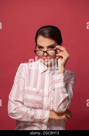 Portrait of smart attractive positive woman in glasses looking at camera Stock Photo