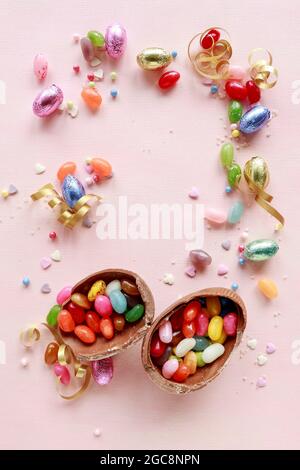 Chocolate Easter eggs and other sweets on pink background. Party dessert Stock Photo