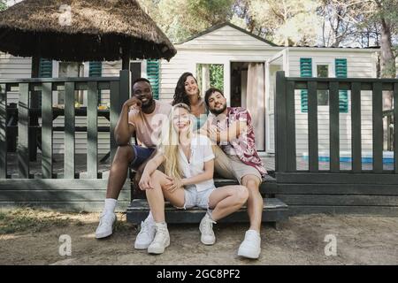 Happy multiracial people from different culture and race having fun outdoor at countryside farm house - Main focus on front girl Stock Photo
