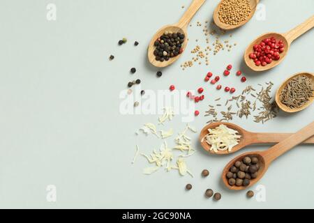 Wooden spoons with different spices on light gray background Stock Photo