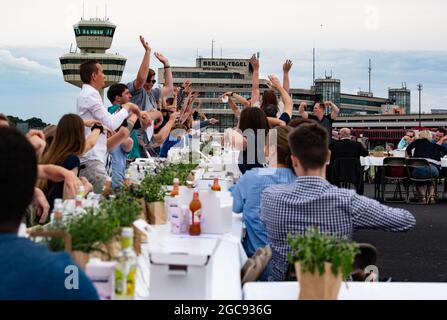 Berlin, Germany. 07th Aug, 2021. Participants at the 'Freedom Dinner' sit at tables on the runway of the former Tegel Airport. The economic administration, the Senate Chancellery, Messe Berlin and Tourism Marketing had invited to the open-air event. Credit: Paul Zinken/dpa/Alamy Live News Stock Photo