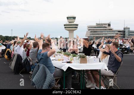 Berlin, Germany. 07th Aug, 2021. Participants at the 'Freedom Dinner' sit at tables on the runway of the former Tegel Airport. The economic administration, the Senate Chancellery, Messe Berlin and Tourism Marketing had invited to the open-air event. Credit: Paul Zinken/dpa/Alamy Live News Stock Photo