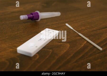 Rapid Covid-19 coronavirus strip test cassette for antibody or sars-cov-2 virus isolated on brown wooden background Stock Photo