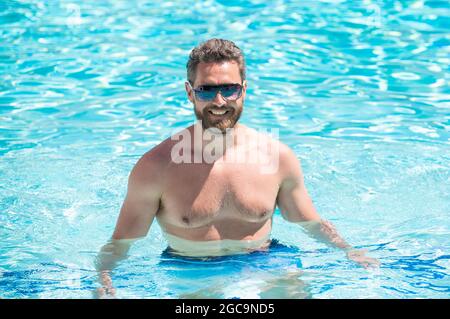 happy muscular man in glasses swimming in pool on summer, summertime Stock Photo