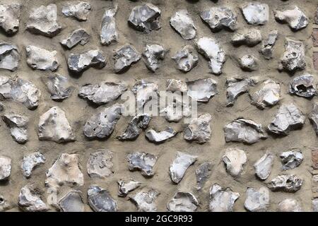 Flint wall background showing rough grey stones embedded in concrete Stock Photo