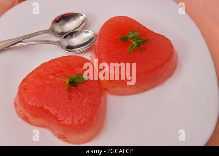 Close-up of some heart-shaped jellies on a plate to share the sweet with a couple Stock Photo
