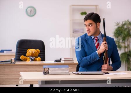 Young employee and his toy bear boss in funny concept Stock Photo