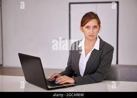 Woman with laptop works using internet during telework. Stock Photo
