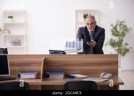 Aged businessman employee sitting at workplace Stock Photo