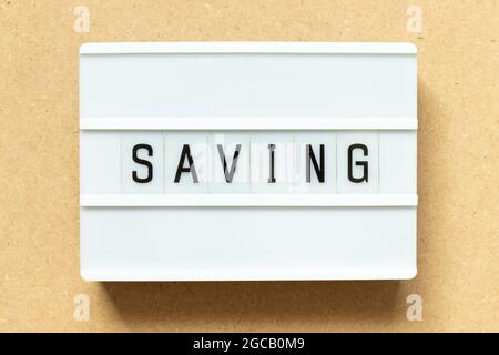 Lightbox with word saving on wood background Stock Photo