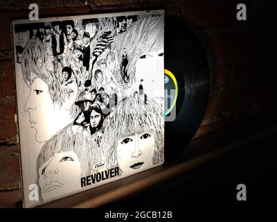 Closeup of The Beatles Revolver Vinyl Record and Cover Leaning Against Brick Wall Stock Photo