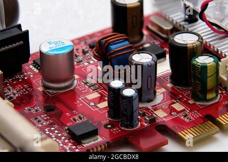 Macro circuits and microchips on graphics card red board Stock Photo
