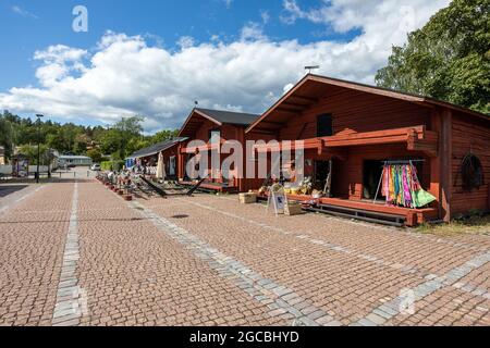 LOVIISA, FINLAND - 04-08-2021: Old wooden buildings turned into souvenir shops, cafes and restaurants in Laivasilta tourist area in Old Lower Town of Stock Photo