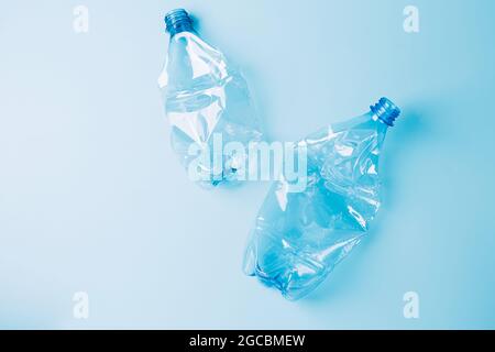 Used empty crumpled plastic bottles on blue background. Recycling recycled plastic. Pollution, environmental protection. Stock Photo
