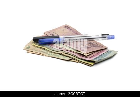 Old dirty bangladeshi banknotes with two pens on isolated white background Stock Photo