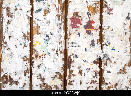 Colorful torn posters on grunge old walls as background or texture Stock Photo