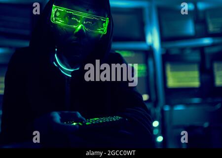 Cyber hacker breaks into databases to obtain information using a computer. Cybercrime and data security concept. Stock Photo