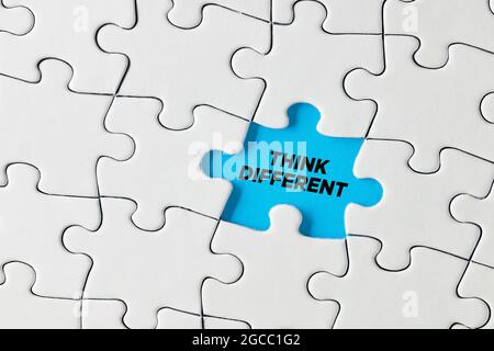 Think different written on blue missing puzzle piece. Creative thinking concept. Stock Photo