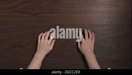 Top view man hands finger tap on black walnut table with copy space, wide photo Stock Photo