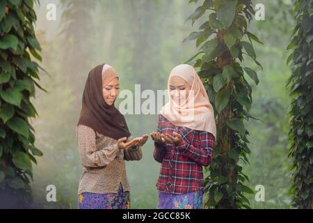 Two young asian muslim woman Praying on green outdoor,vintage style Stock Photo