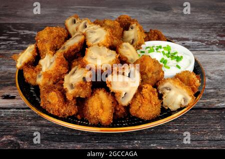 Whole breaded button mushrooms with soured cream and chive dip Stock Photo