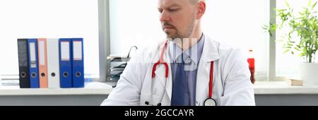 Male doctor working on laptop in medical office