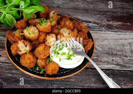 Whole breaded button mushrooms with soured cream and chive dip Stock Photo