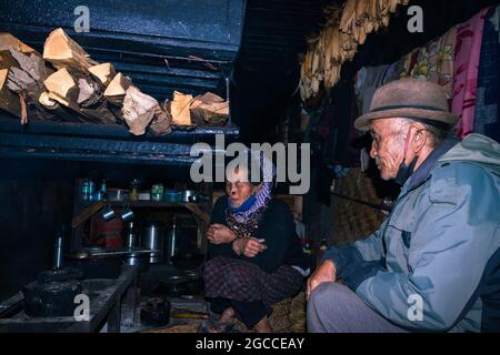 apatani tribal couple at their home near fire place cooking food at evening from flat angle image is taken at ziro arunachal pradesh india. it is one Stock Photo