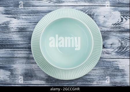 Empty blue plates over wooden table background. View from above with copy space Stock Photo