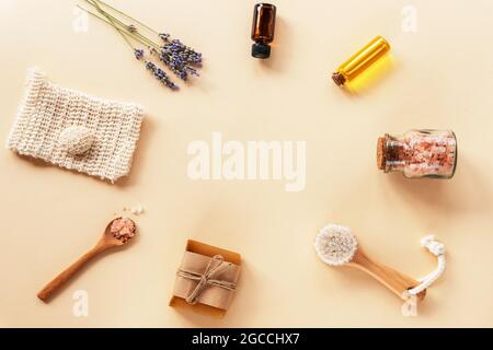 Bath accessories and natural cosmetics, himalayan pink salt in glass jar, essential oil and lavender flowers on beige background. Zero waste concept. Stock Photo