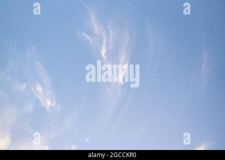 Wispy white clouds scattered across blue summer sky Stock Photo