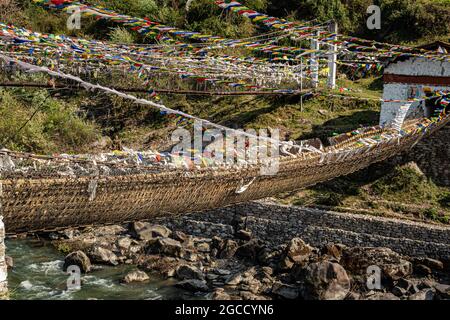 ancient holy iron bridge with many buddhist holy flags from flat angle image is taken at chaksam bridge tawang arunachal pradesh india. Stock Photo