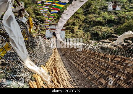 ancient holy bamboo bridge with many buddhist holy flags from unique perspective image is taken at chaksam bridge tawang arunachal pradesh india. Stock Photo