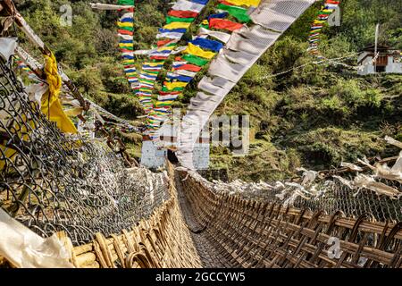 ancient holy bamboo bridge with many buddhist holy flags from unique perspective image is taken at chaksam bridge tawang arunachal pradesh india. Stock Photo